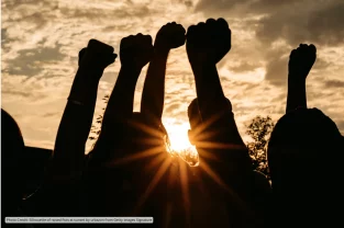Photo Credit_ Silhouette of raised fists at sunset by urbazon from Getty Images Signature